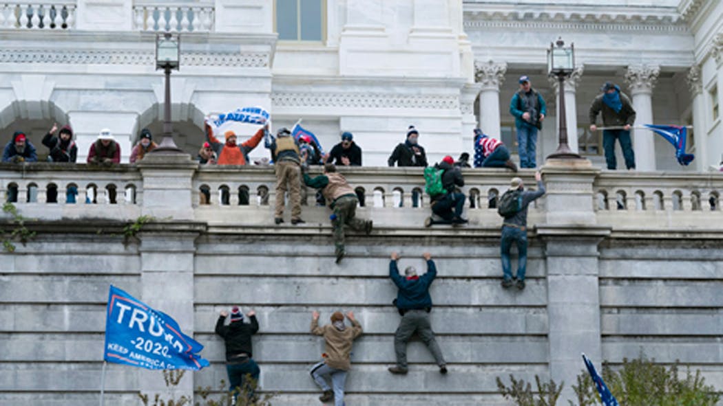 Supporters of President Donald Trump climb the west wall of th