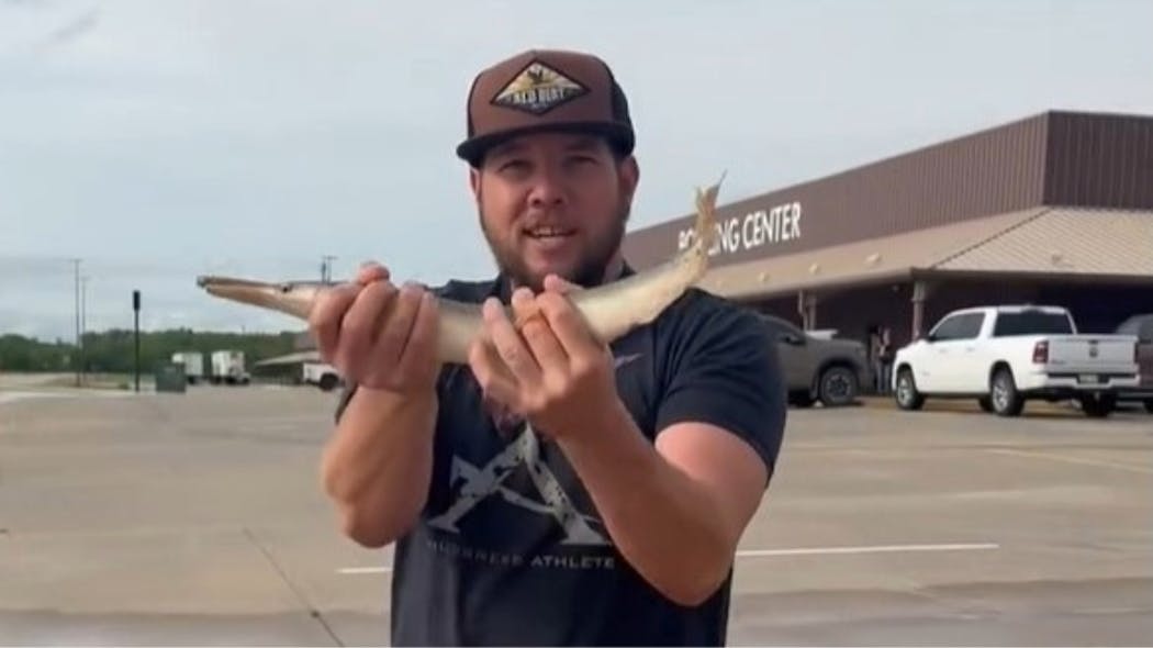 Nathan Williams catches a gar in a flooded parking lot