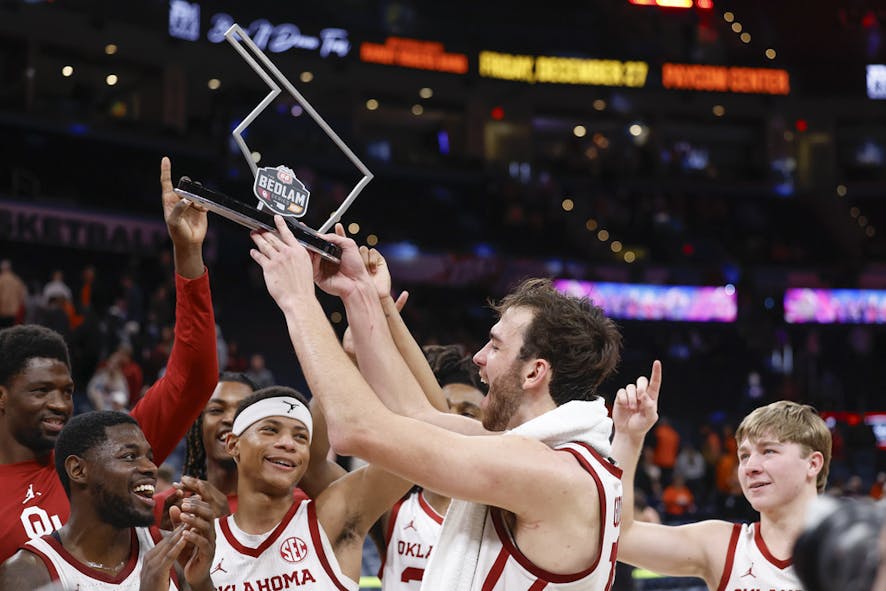 Oklahoma forward Sam Godwin (10) holds up the Bedlam trophy