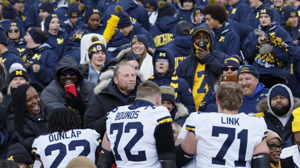 Michigan players and fans celebrate win over Ohio State.